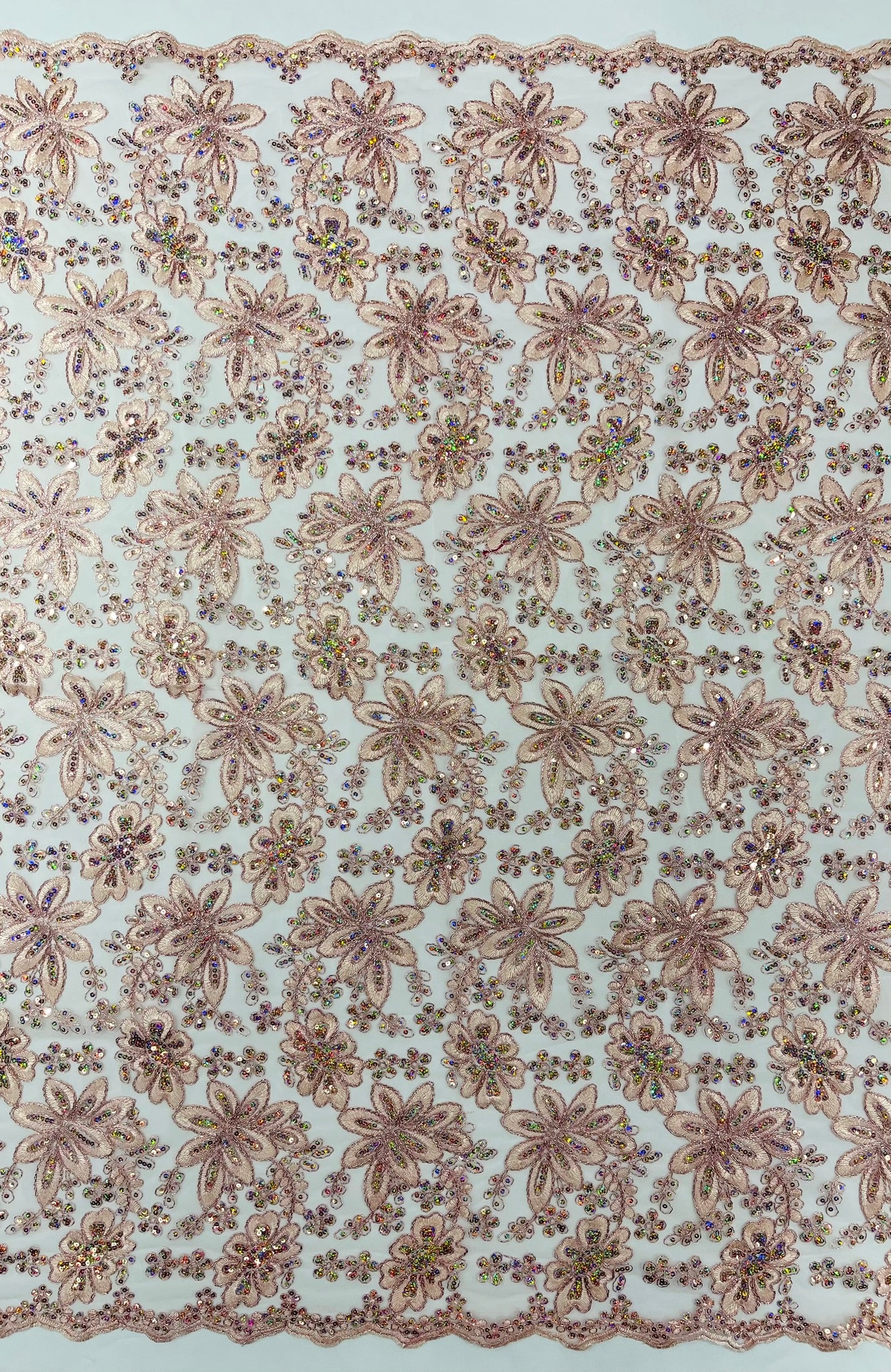 Metallic floral lace design embroidered with holographic sequins on a mesh 54” wide.