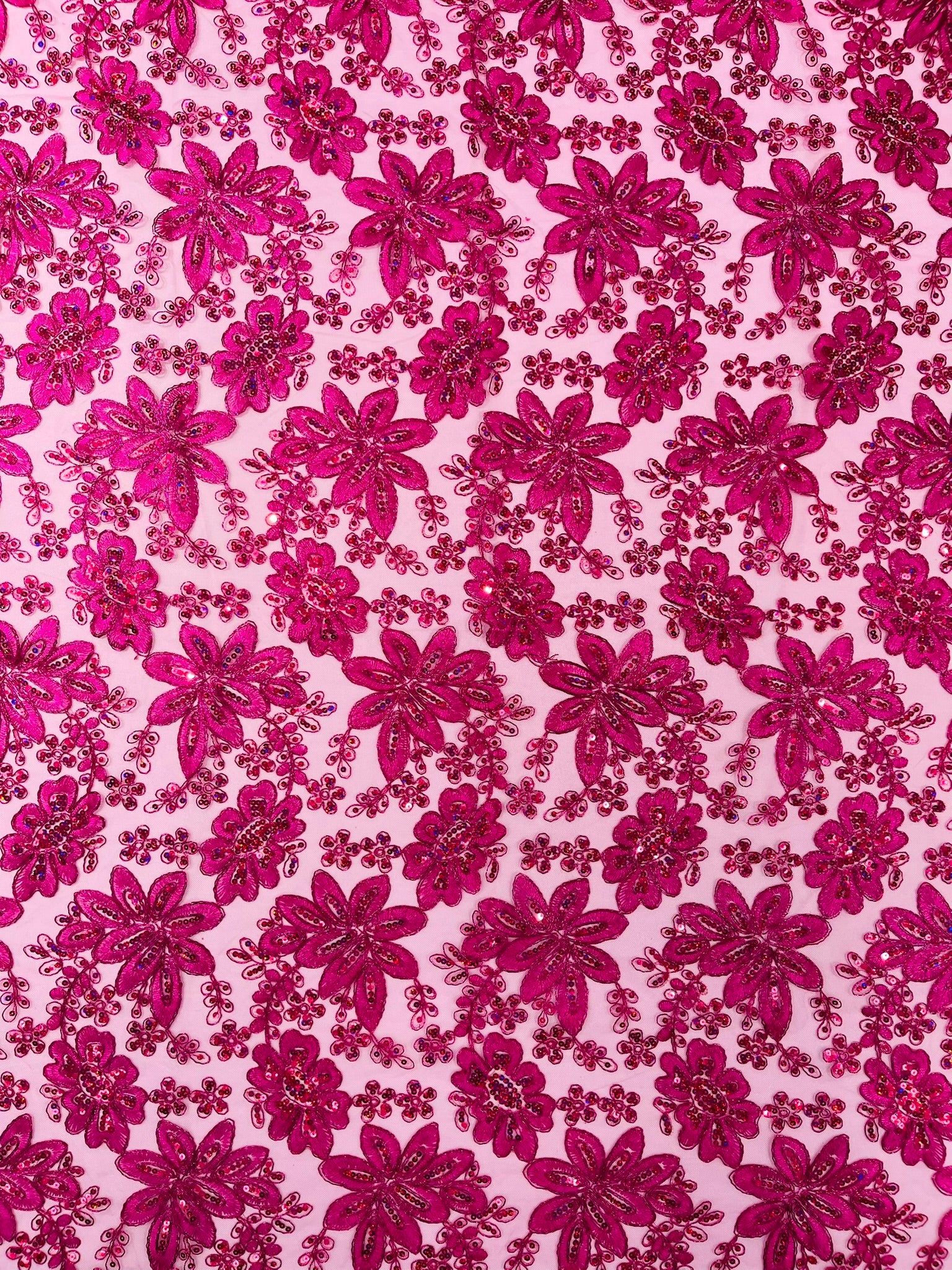 Metallic floral lace design embroidered with holographic sequins on a mesh 54” wide.