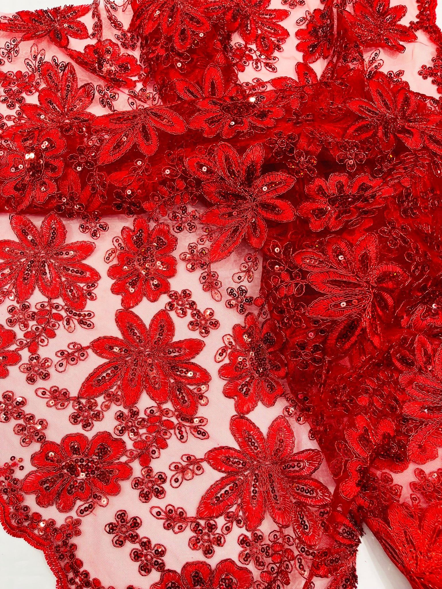 Metallic floral lace design embroidered with holographic sequins on a mesh 54” wide.