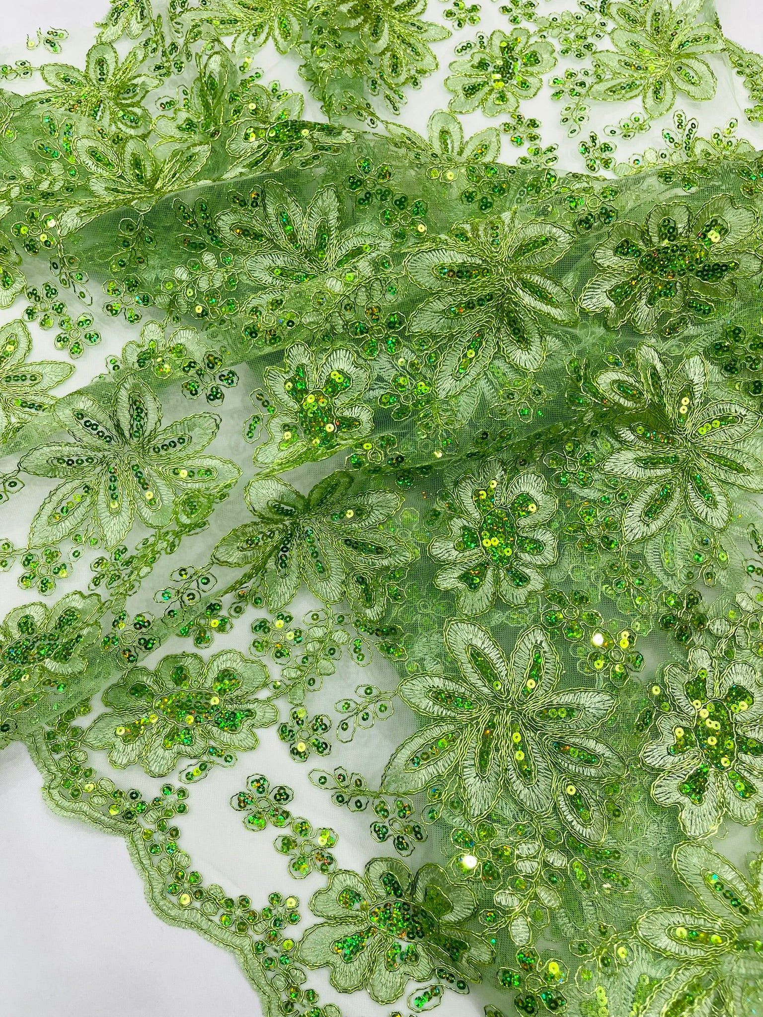 Metallic floral lace design embroidered with holographic sequins on a mesh 54” wide.