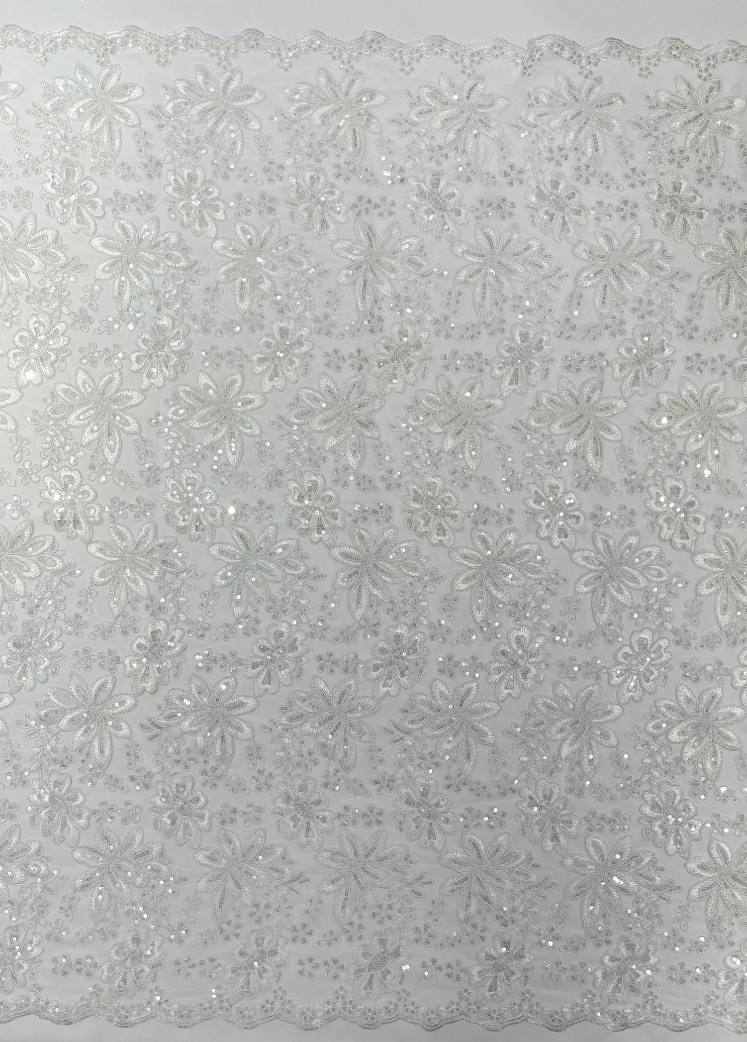 Metallic floral lace design embroidered with holographic sequins on a mesh 54” wide.