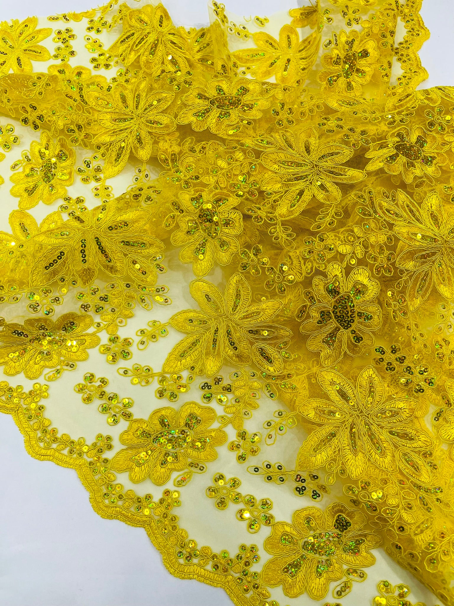 Metallic floral lace design embroidered with holographic sequins on a mesh 54” wide.